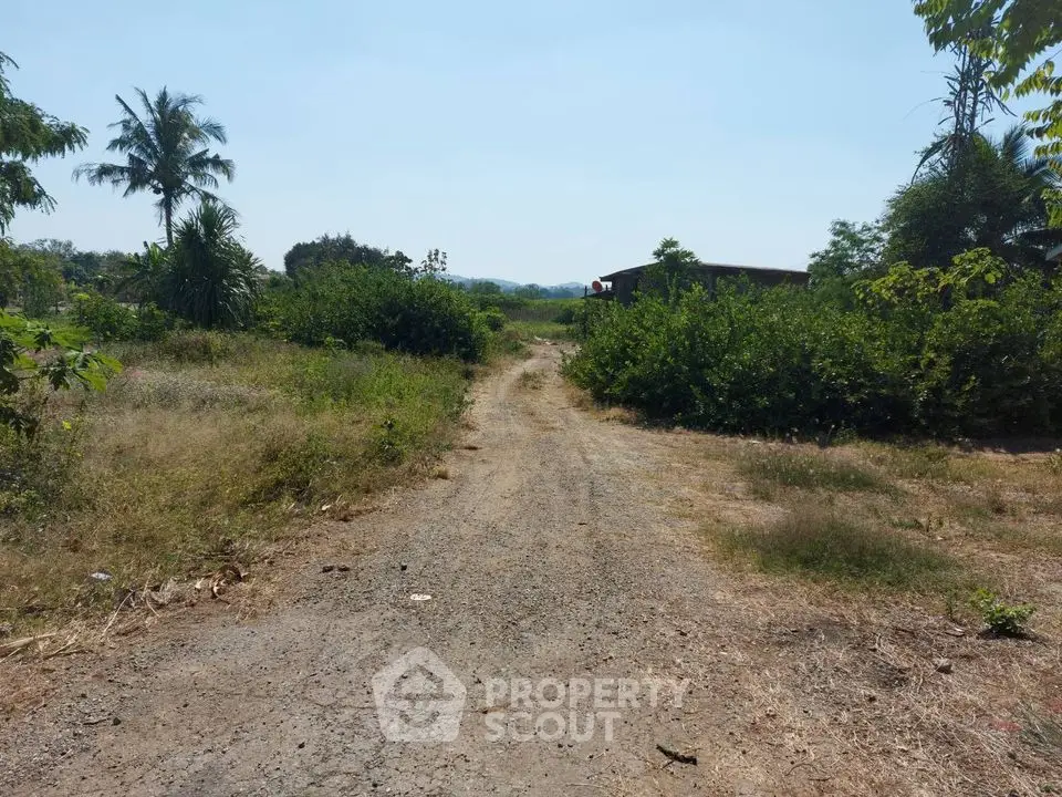 Expansive plot of land with lush greenery and distant mountain views, ideal for development.