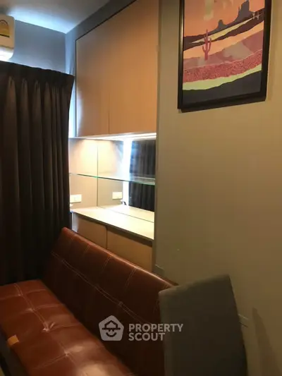 Cozy living room with modern sofa and stylish wall art in a compact apartment.