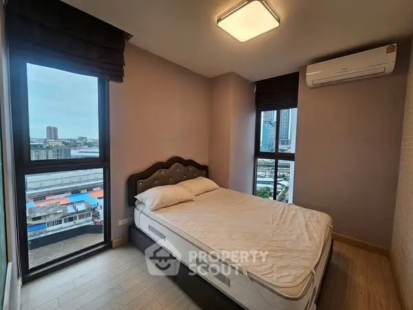 Modern bedroom with city view, featuring a comfortable bed and air conditioning.