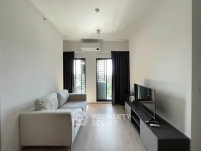 Modern living room with sleek furniture and balcony view in a stylish apartment.
