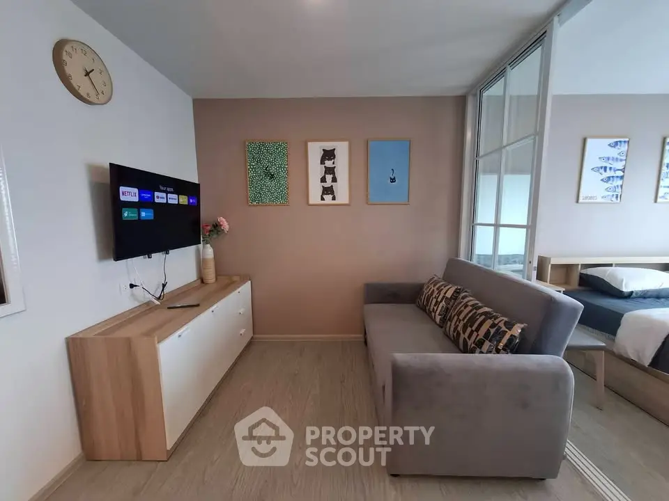 Modern living room with stylish decor and wall art, featuring a cozy gray sofa and wall-mounted TV.