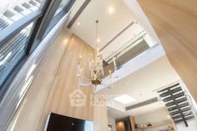 Luxurious modern interior with high ceilings and elegant chandelier in a stylish living space.