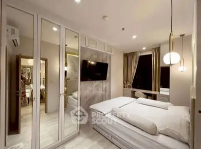 Luxurious bedroom with mirrored closets and elegant lighting, perfect for modern living.