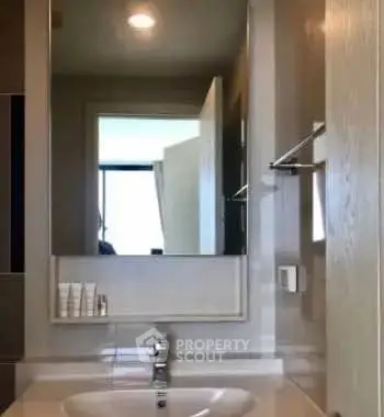 Modern bathroom with sleek sink and large mirror in contemporary apartment.