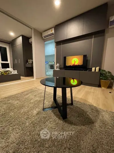 Modern living room with sleek furniture and ambient lighting, featuring a stylish black coffee table and cozy carpet.