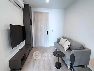 Modern living room with sleek furniture and wall-mounted TV, perfect for cozy urban living.