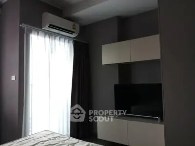 Modern bedroom with air conditioning and TV unit, featuring sleek design and natural light.