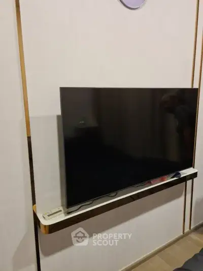 Modern living room with sleek wall-mounted TV and minimalist design.