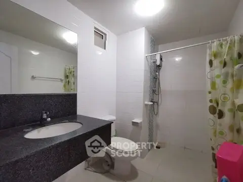 Modern bathroom with sleek countertop and shower area in a contemporary home.