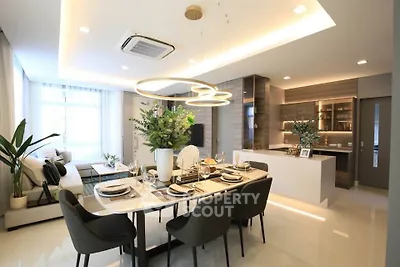 Luxurious open-plan living and dining area with modern decor and elegant lighting.
