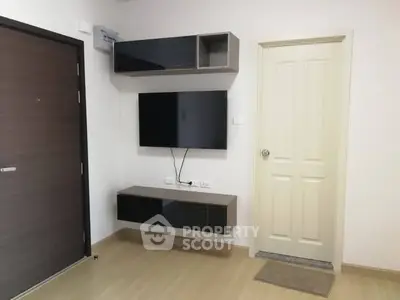 Modern living room with wall-mounted TV and sleek storage units.