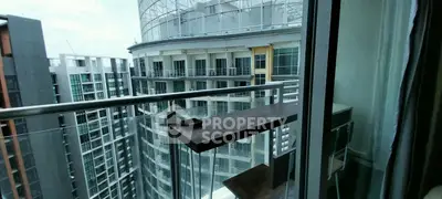 Modern balcony view with glass railing overlooking urban high-rise buildings.