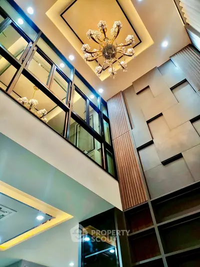 Luxurious high-ceiling living room with elegant chandelier and modern design elements.