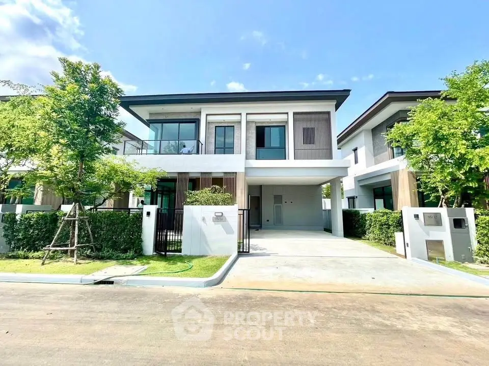 Modern two-story house with sleek design and spacious driveway in a serene neighborhood.