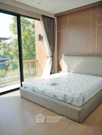 Modern bedroom with large window and balcony view