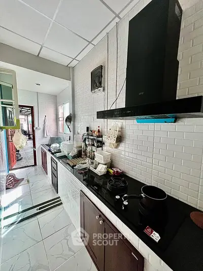 Modern kitchen with sleek black countertops and white brick backsplash