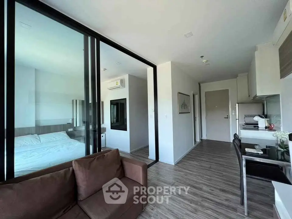 Modern apartment interior with open layout, featuring a cozy living area and sleek kitchen design.