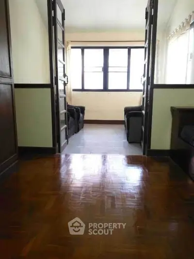 Spacious living area with wooden flooring and ample natural light.