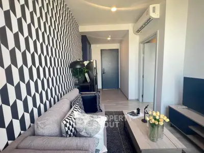 Stylish modern living room with geometric wallpaper and cozy seating area.