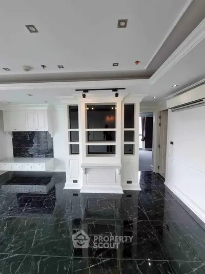 Luxurious living room with elegant black marble flooring and modern white cabinetry.