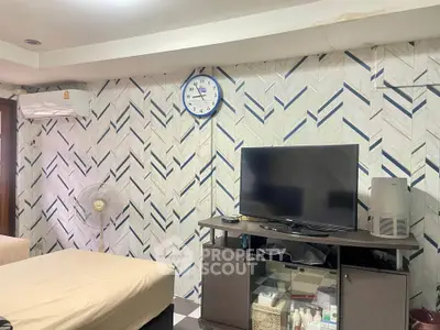 Cozy living room with modern decor, featuring a wall-mounted clock and air conditioning unit.