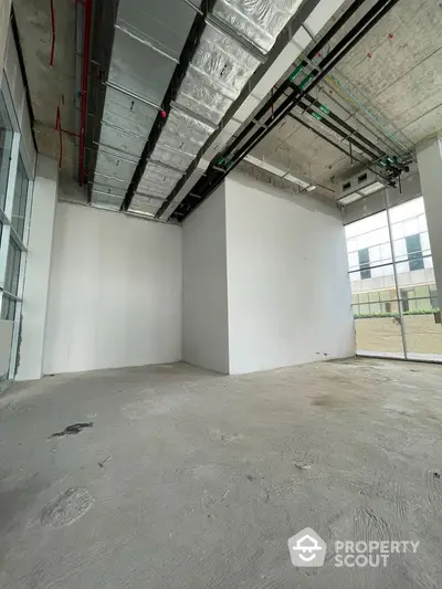 Spacious unfinished commercial space with high ceilings and large windows