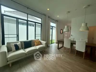 Spacious modern living room with large windows and elegant dining area