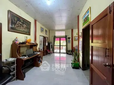 Spacious living room with home office setup and natural lighting