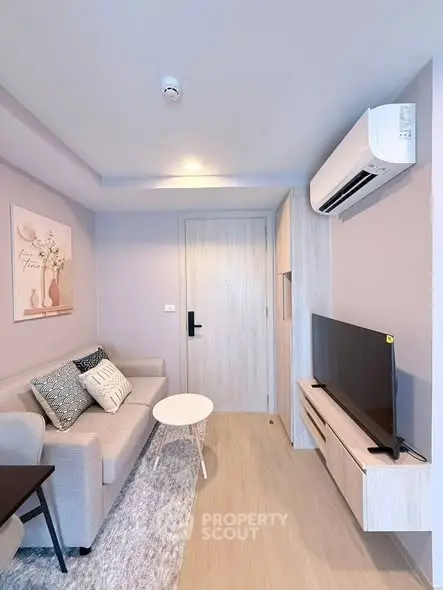 Modern living room with sleek furniture and wall-mounted TV in a stylish apartment.