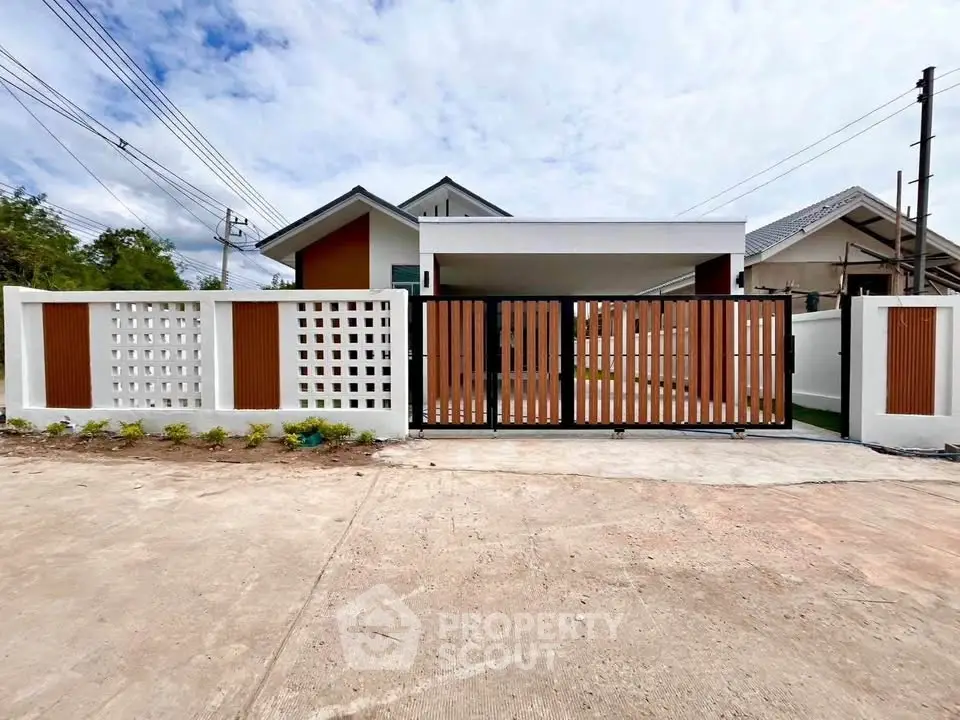 Modern single-story house with stylish wooden gate and white fence