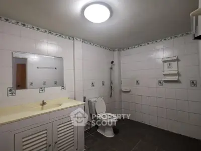 Spacious bathroom with tiled walls and modern fixtures