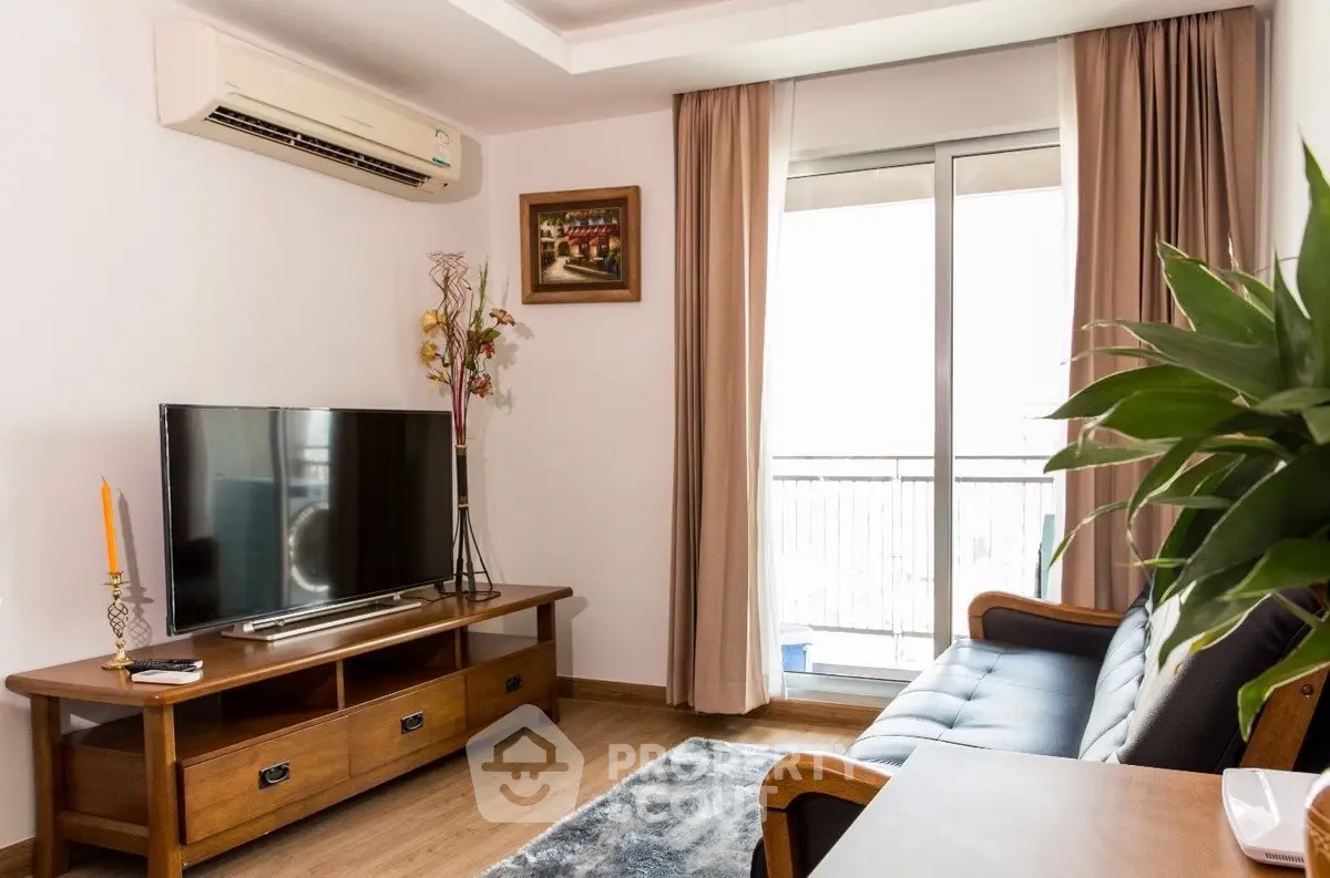 Cozy living room with modern furnishings, ample natural light, and balcony access, perfect for relaxation and entertainment.