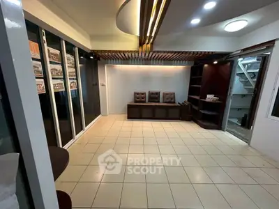 Spacious modern living room with stylish ceiling design and ample natural light.