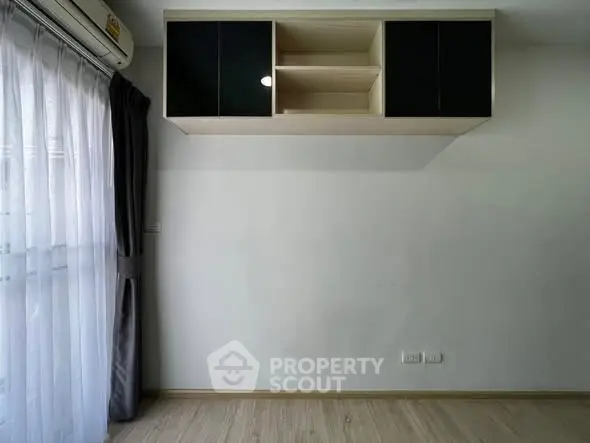 Minimalist room with wall-mounted storage and large window with sheer curtains