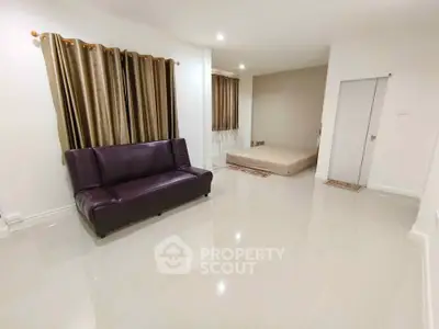 Spacious living room with modern sofa and bed, featuring elegant curtains and glossy tiled flooring.