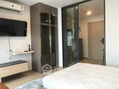 Modern bedroom with sleek design and wall-mounted TV in a stylish apartment.