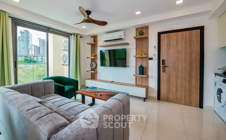 Modern living room with city view, featuring stylish furniture and a wall-mounted TV.