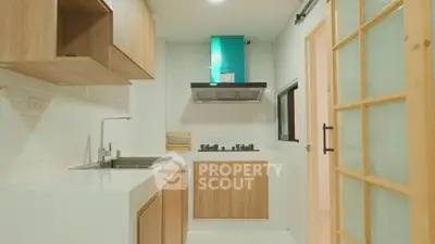 Modern kitchen with sleek wooden cabinets and gas stove in compact layout