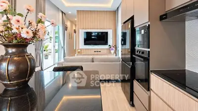 Modern open-layout kitchen and living room with sleek appliances and elegant decor.