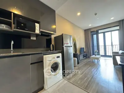 Modern open-layout kitchen and living room with balcony view in stylish apartment.