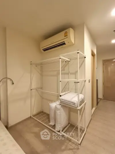 Modern bedroom with air conditioning and storage shelves, ideal for urban living.