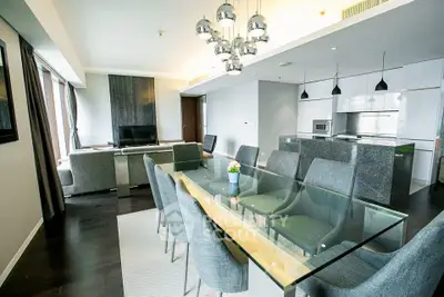 Luxurious open-plan living and dining area with modern decor and elegant lighting in a high-end apartment.