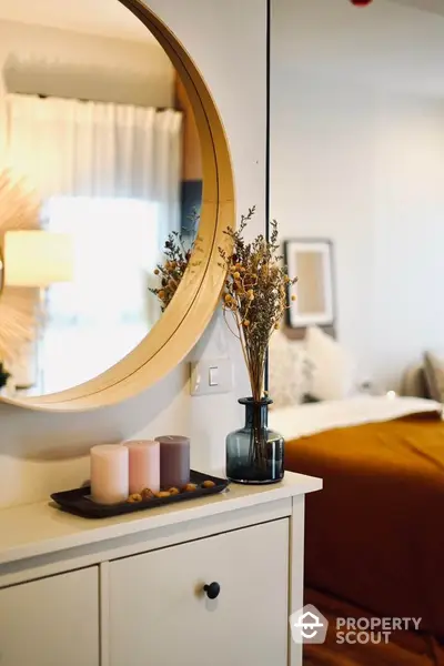 Stylish bedroom with modern decor and elegant mirror reflecting cozy ambiance.