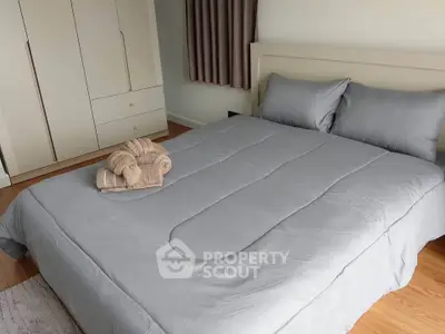 Cozy bedroom with modern wardrobe and neatly arranged bed linens, perfect for relaxation.