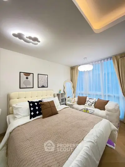 Elegant bedroom with cozy bed, stylish decor, and natural light from large window.