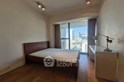 Modern bedroom with city view and minimalist decor in high-rise apartment.