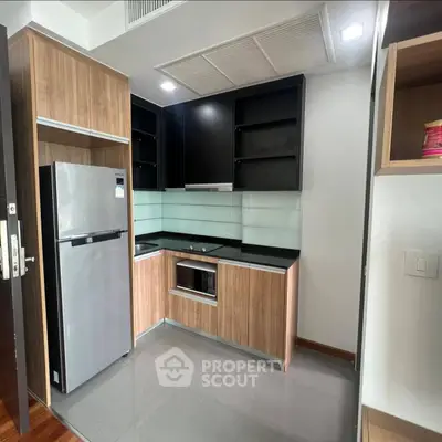 Modern kitchen with sleek cabinetry and stainless steel appliances in a contemporary apartment.