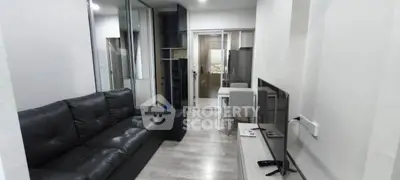 Modern living room with sleek black sofa and glass sliding doors
