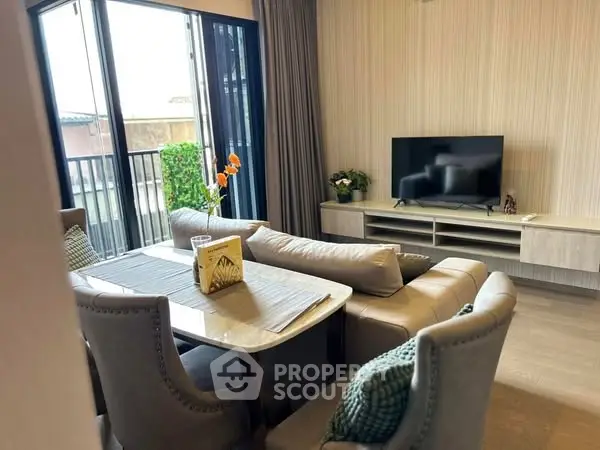 Stylish living room with modern furniture and large windows opening to a balcony.