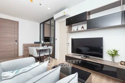 Modern living room with sleek furniture and wall-mounted TV in a stylish apartment.